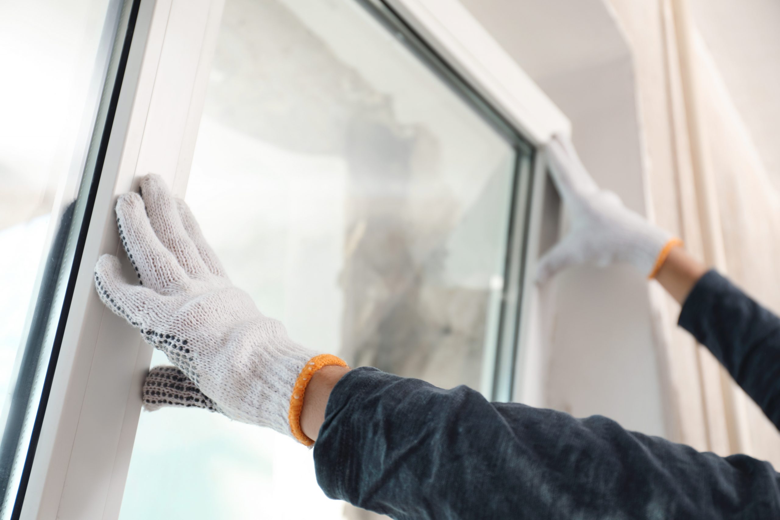 Why Buy New? Part III: Energy Efficiency - Worker installing plastic window indoors, closeup view